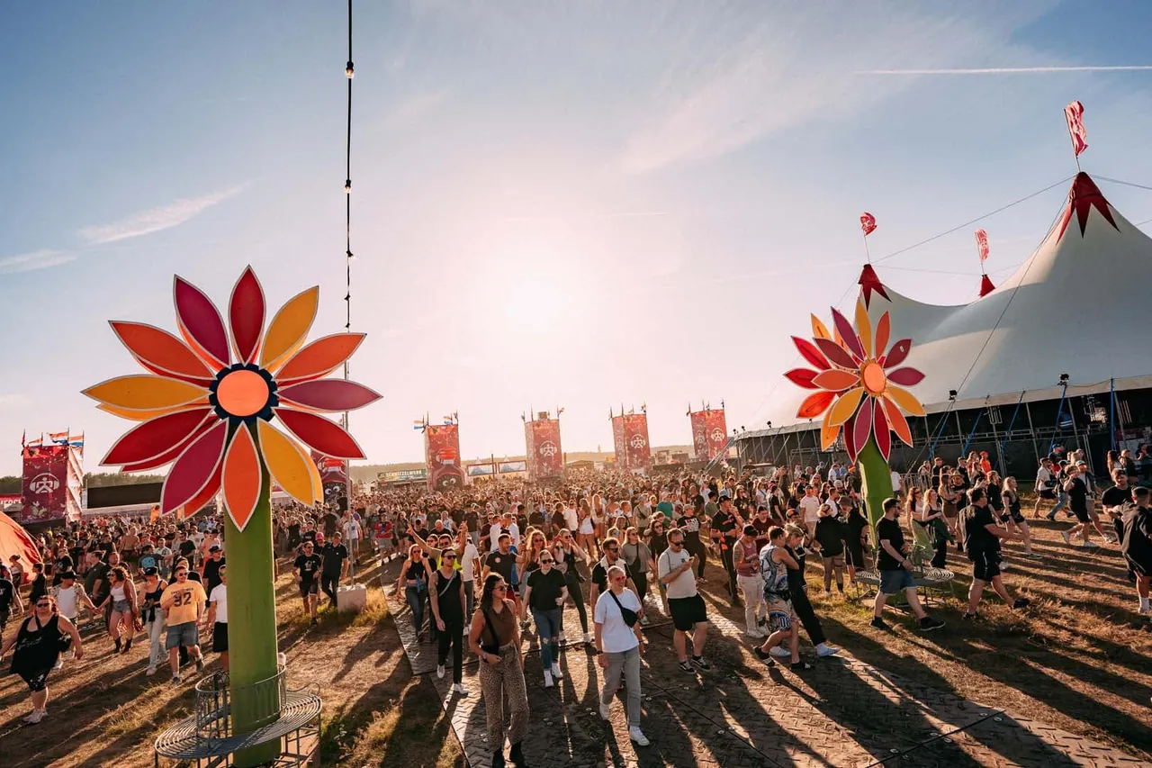 Festivalgoers among the giant flowers of the Netherlands edition decor, in 2026.