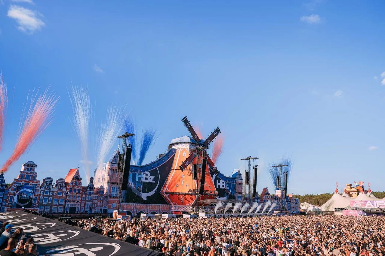 The Mainstage by day in 2026: orange windmill, Dutch house facades and pyrotechnic jets.