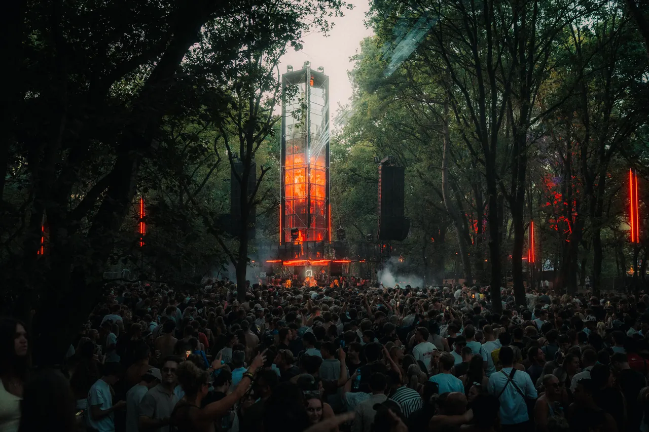 La scène de la forêt et sa tour lumineuse à la tombée du jour, le 12 juillet 2026.