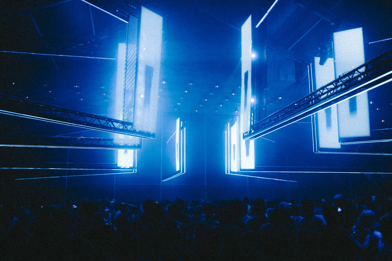 Colonnes de LED et lumière bleue sous une halle, le 12 juillet 2026 au soir.