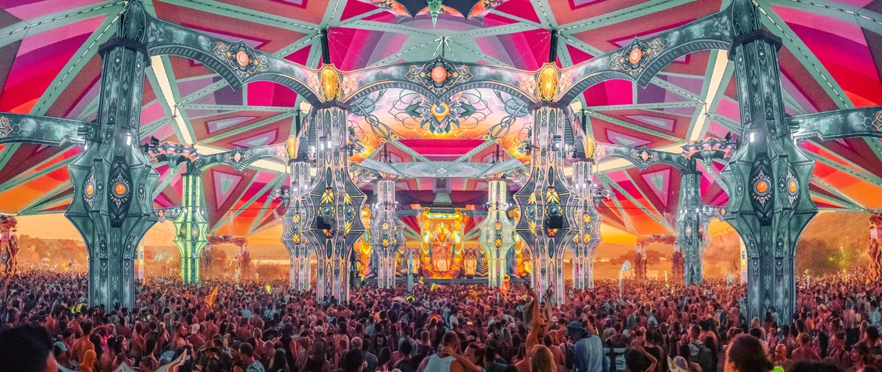 Le Dance Temple de l'édition 2022 en panorama : piliers sculptés, décor psychédélique et piste noire de monde.