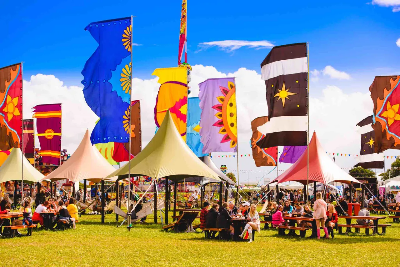 Drapeaux et tables du village des campeurs, le vendredi de l'édition 2018.