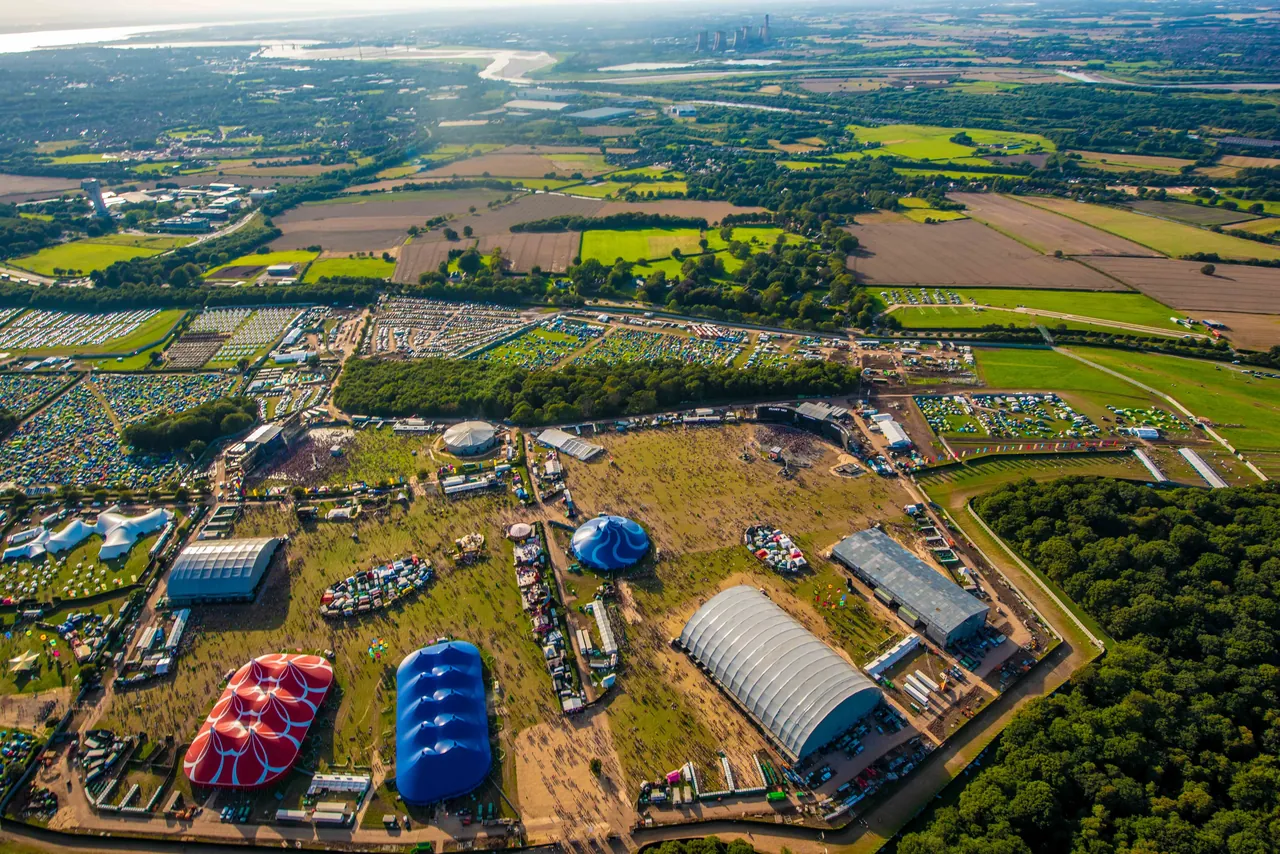 Vue aérienne du site de Daresbury en 2019 : scènes, chapiteaux et campings au milieu de la campagne du Cheshire.