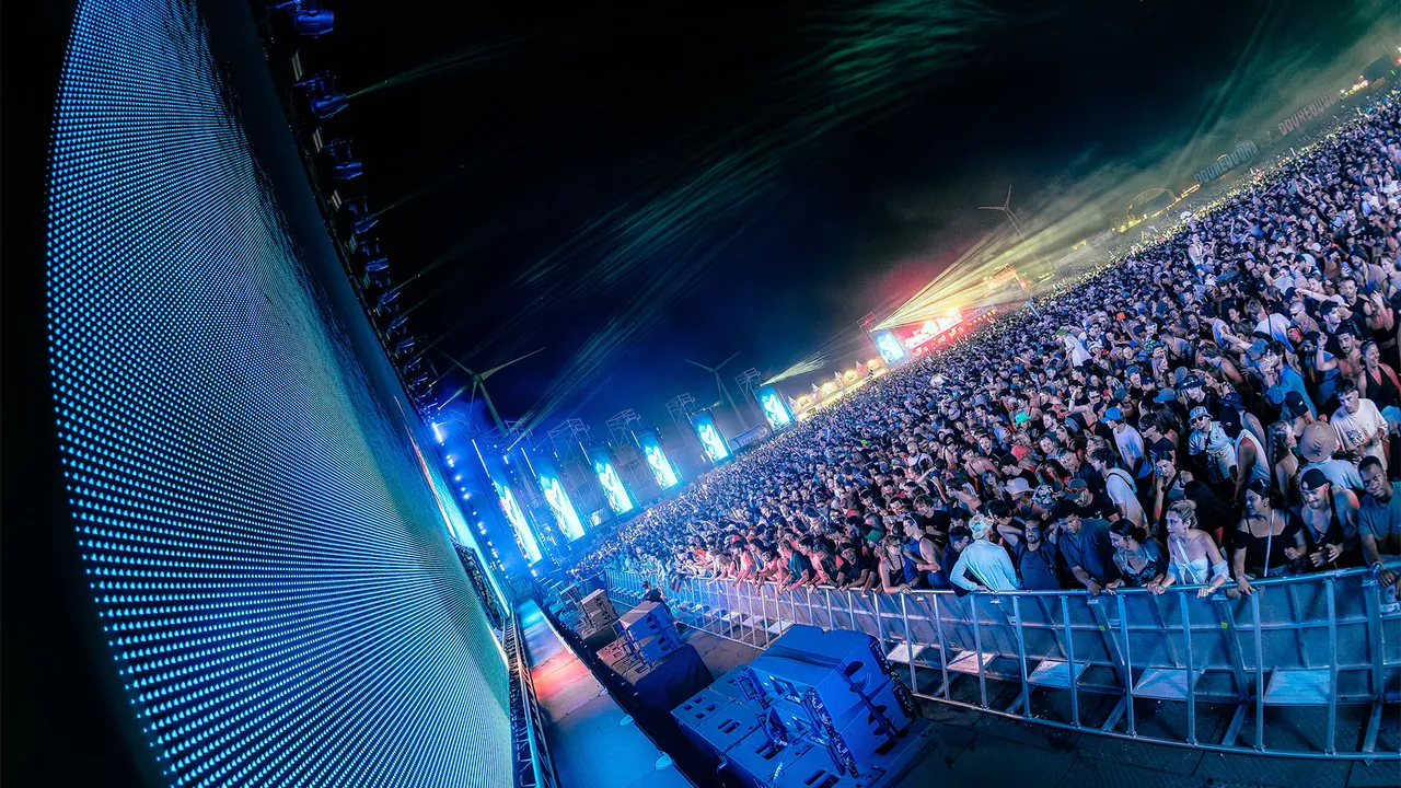De Balzaal, the techno and house tent, packed to the rafters, seen fisheye from the side of the stage.
