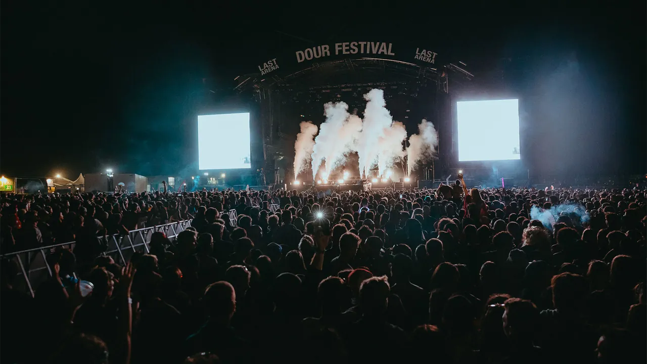 The crowd in front of The Last Arena during a night show, with CO2 jets on stage.