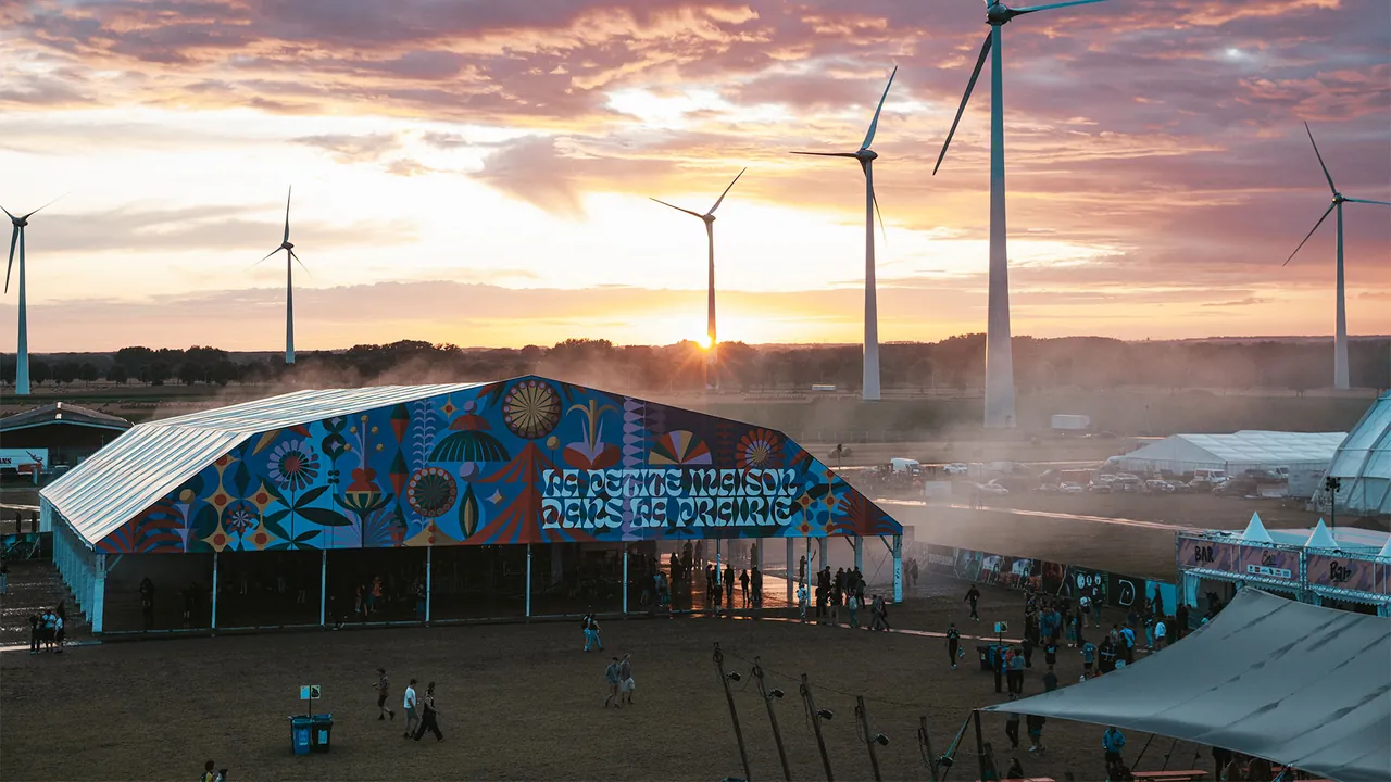 La Petite Maison dans la Prairie at sunset, beneath the wind turbines of the site.