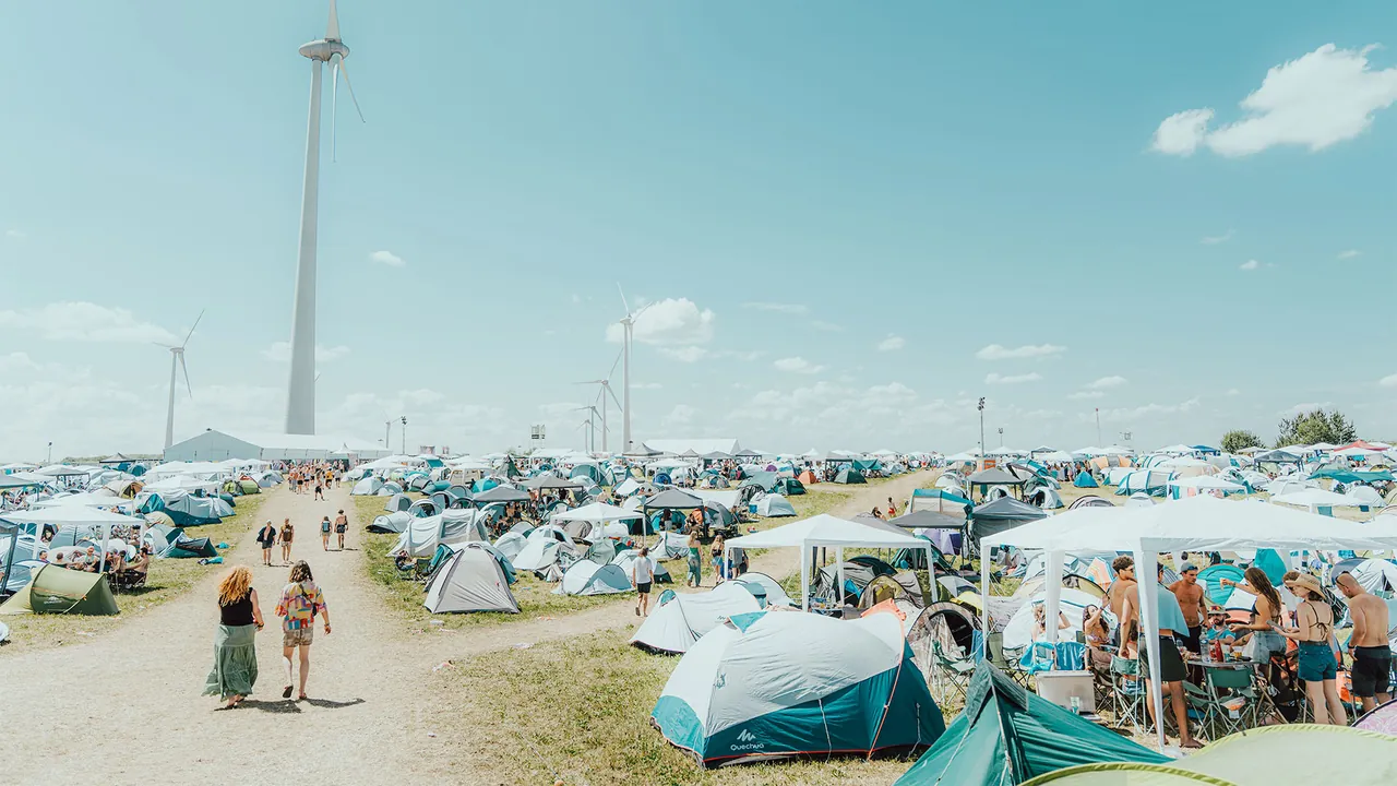 The Regular Camping, a sea of tents under a wind turbine.