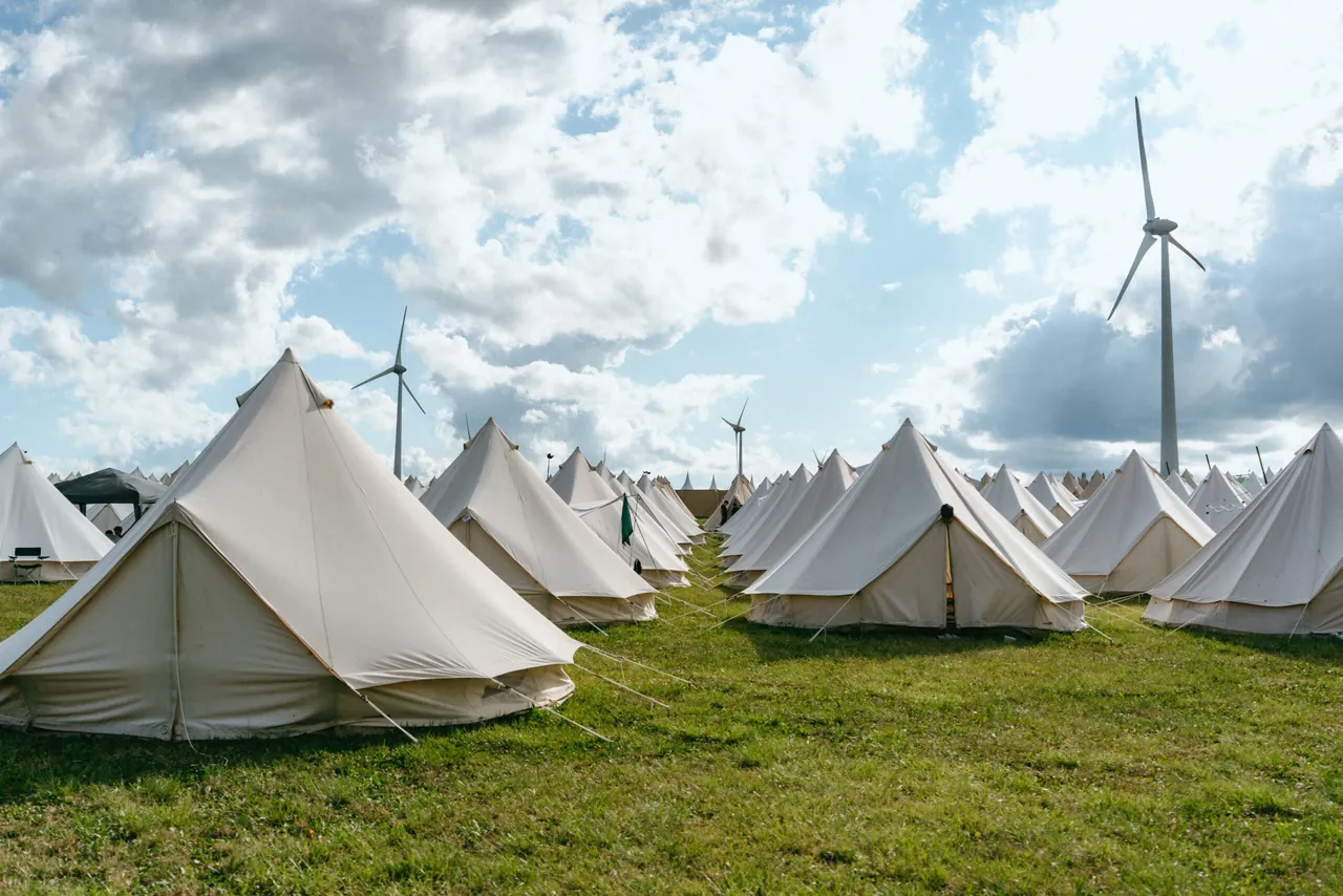 The bell tents of The Village, the ready-pitched accommodation area, beneath the wind turbines.