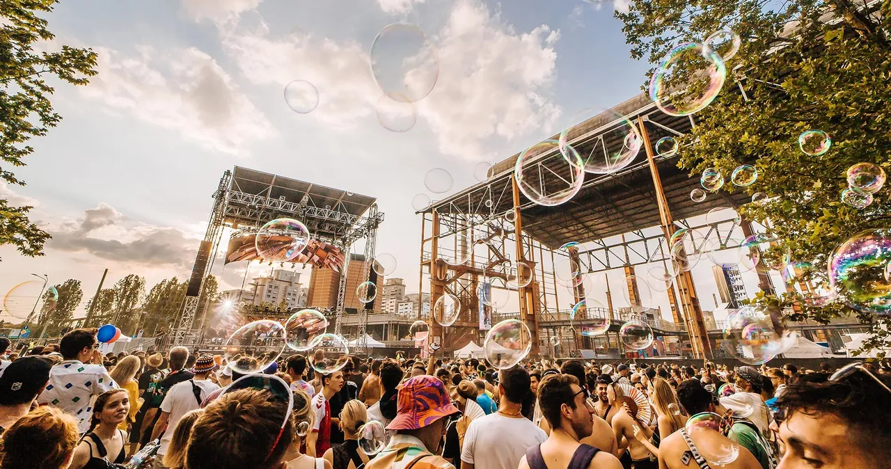 Soap bubbles above the crowd, in front of a stage and the old steelworks frame.