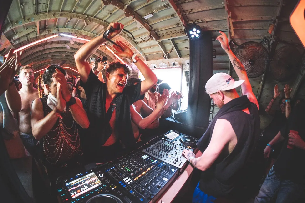 Inside the aircraft fuselage turned into a club, DJ and crowd side by side.
