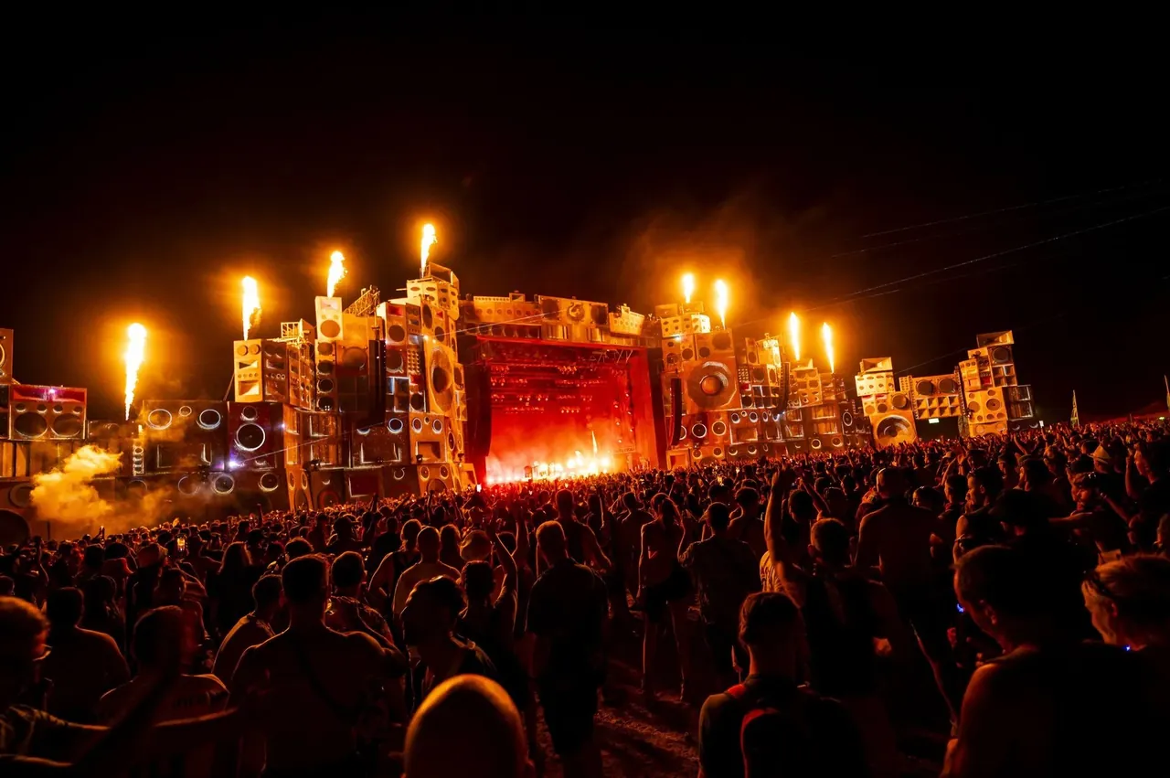The Sound System Temple at night, with flames bursting from the top of the speaker towers.