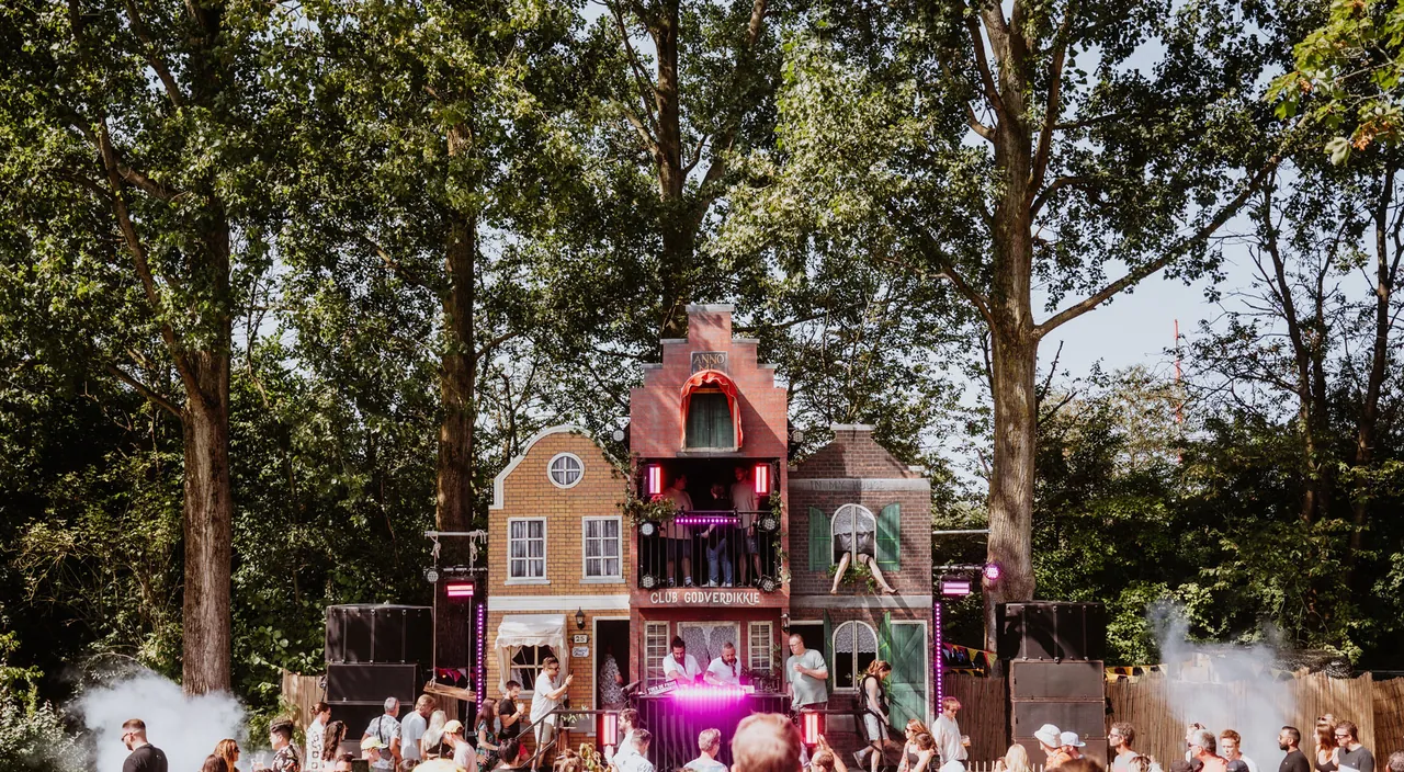 Club Godverdikkie et sa façade de maison de canal plantée entre les arbres.