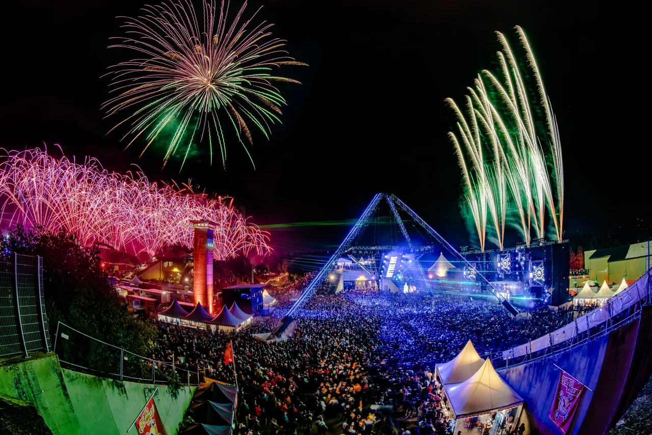 Feu d'artifice sur l'OpenAirFloor en 2023, vu depuis le talus, avec la tour et la pyramide.