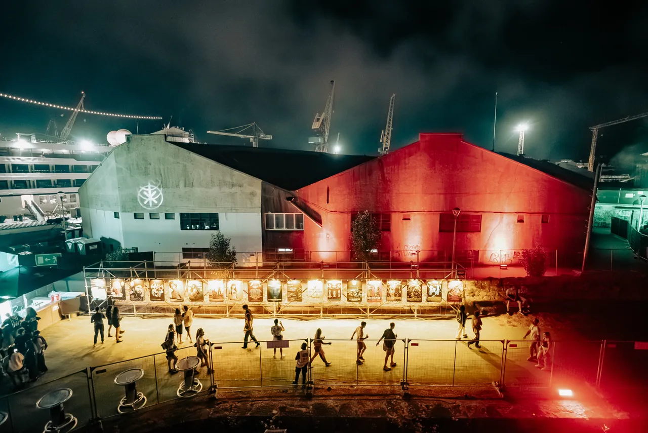 The festival's 20th-anniversary exhibition, a row of lit panels in front of the harbour sheds, night of 6 to 7 August 2026.