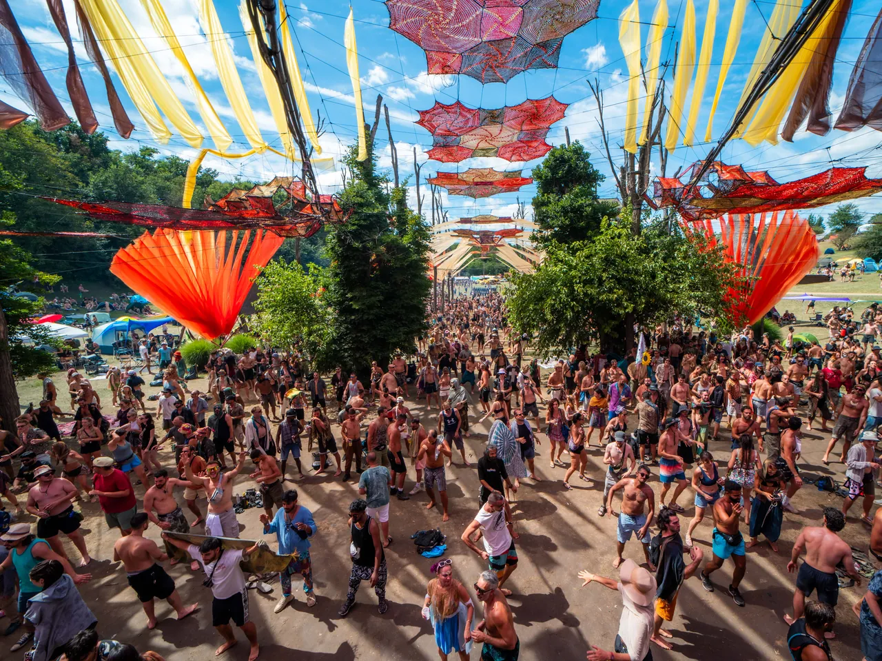 Dancers on the Ozora Stage dancefloor, under the colourful sails, in 2023.