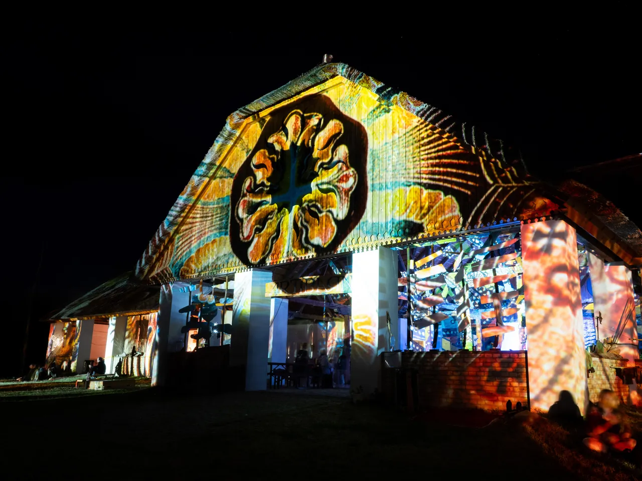 One of the estate's barns covered in psychedelic projections, on the evening of 3 August 2023.