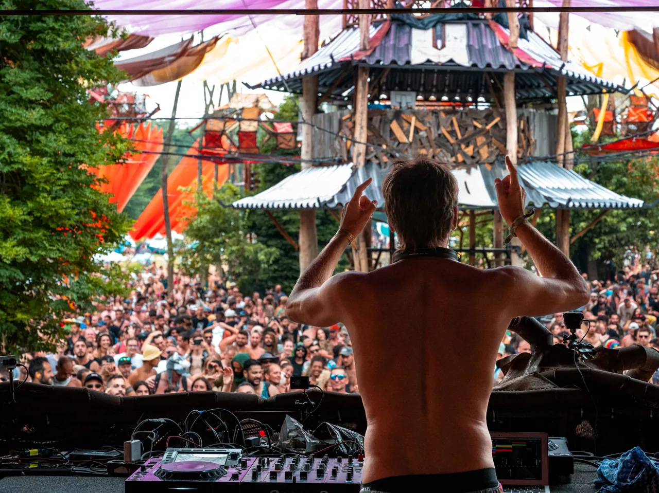 From the Ozora Stage booth: an artist facing the crowd, beneath the stage tower, in 2023.