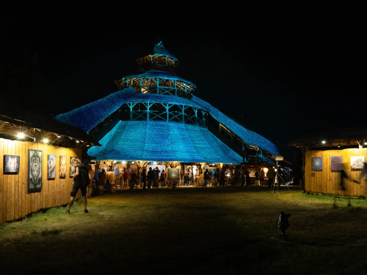 A blue-roofed pavilion and painting galleries lit up at night, in 2023.