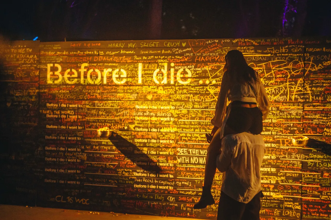 Le mur « Before I die », couvert des vœux écrits à la craie par les festivaliers, le 15 août 2026.