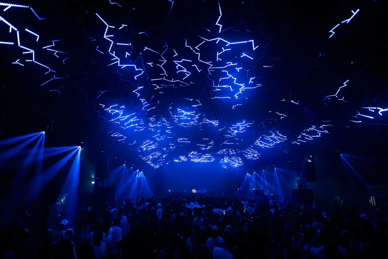 Des éclairs de LED dessinés au plafond d'un floor, au-dessus d'une foule dense, nuit du 1er au 2 avril 2023.