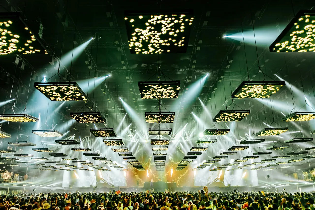 Scène couverte et son plafond de panneaux suspendus, très probablement le Freedom Stage et son « Floating Sky » (2025).