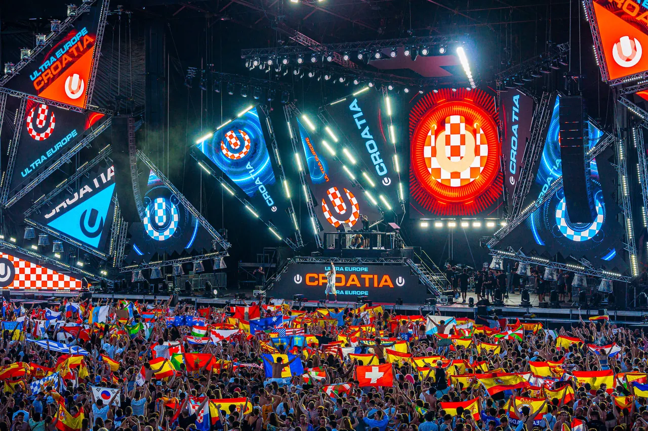 Mer de drapeaux de dizaines de pays devant le Mainstage habillé aux couleurs de la Croatie, en 2023.