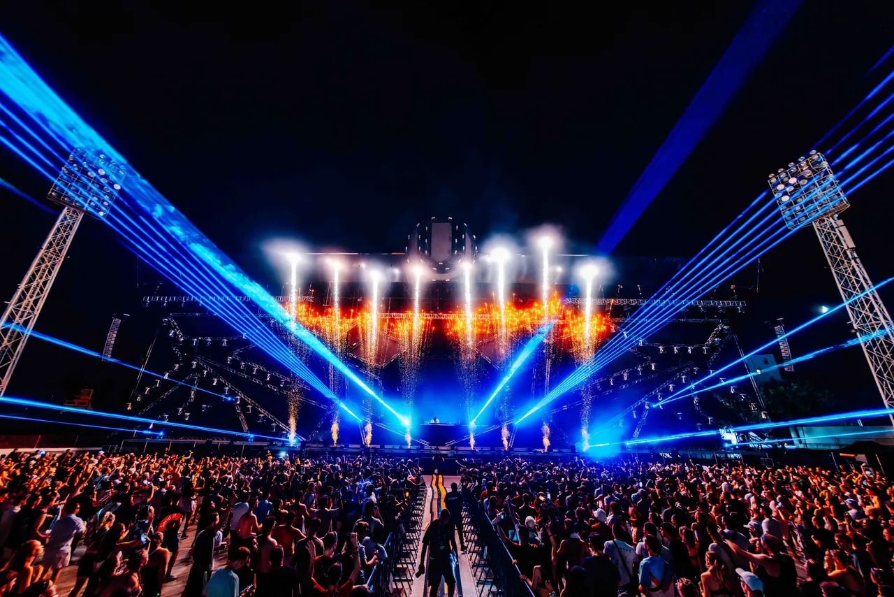 Lasers et pyrotechnie sur le Mainstage, encadré par les pylônes d'éclairage du stade, le 14 juillet 2024.