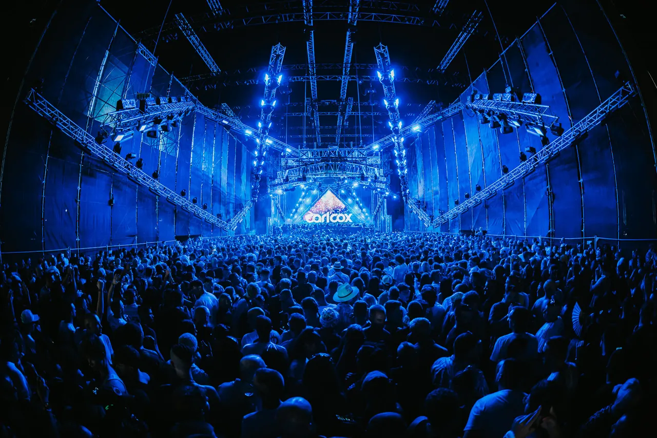 La scène RESISTANCE sous sa structure couverte, dans la nuit du vendredi 11 juillet 2025, le nom de Carl Cox affiché à l'écran.